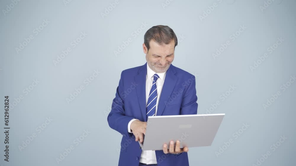 An angry businessman angrily closes his laptop. An angry businessman angrily closes his laptop.