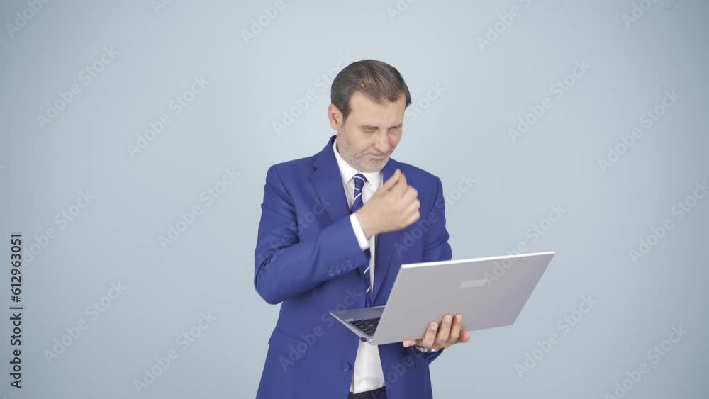 Businessman looking at laptop with tired expression. Businessman looking at laptop with tired expression.
