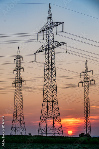Sonnenuntergang hinter Strommasten einer Überlandleitung