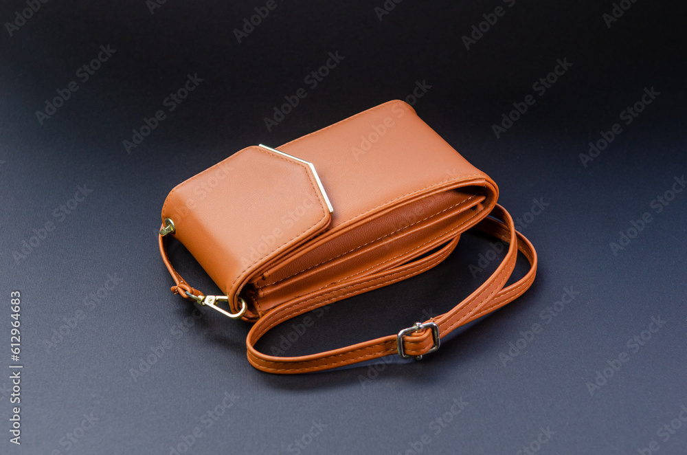 Small women handbag, red, brown, for a mobile phone on a strap. Photo on a black background Small women handbag, red, brown, for a mobile phone on a strap. Photo on a black background