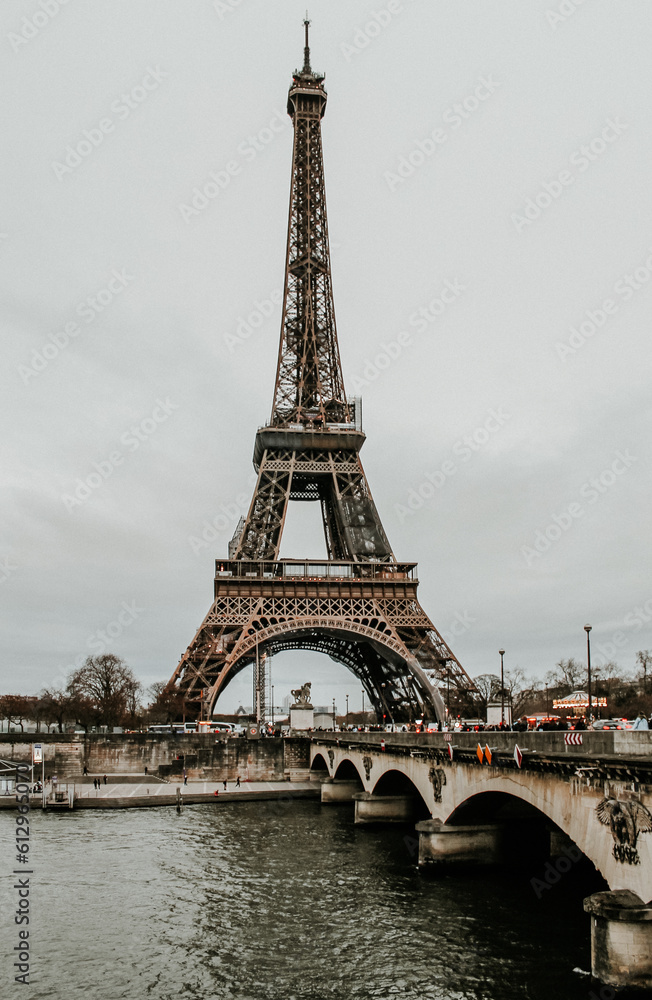 Obraz premium view of the Eiffel Tower in Paris and a bridge on a cloudy day