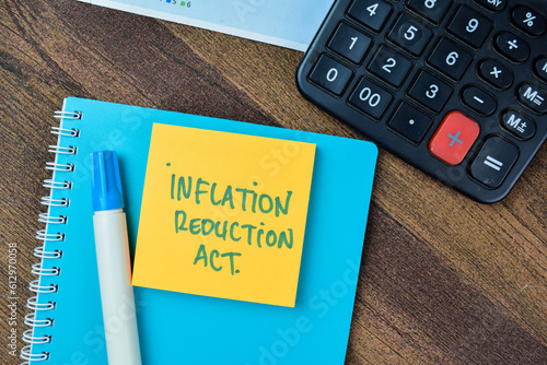 Concept of Inflation Reduction Act write on sticky notes isolated on Wooden Table. photo