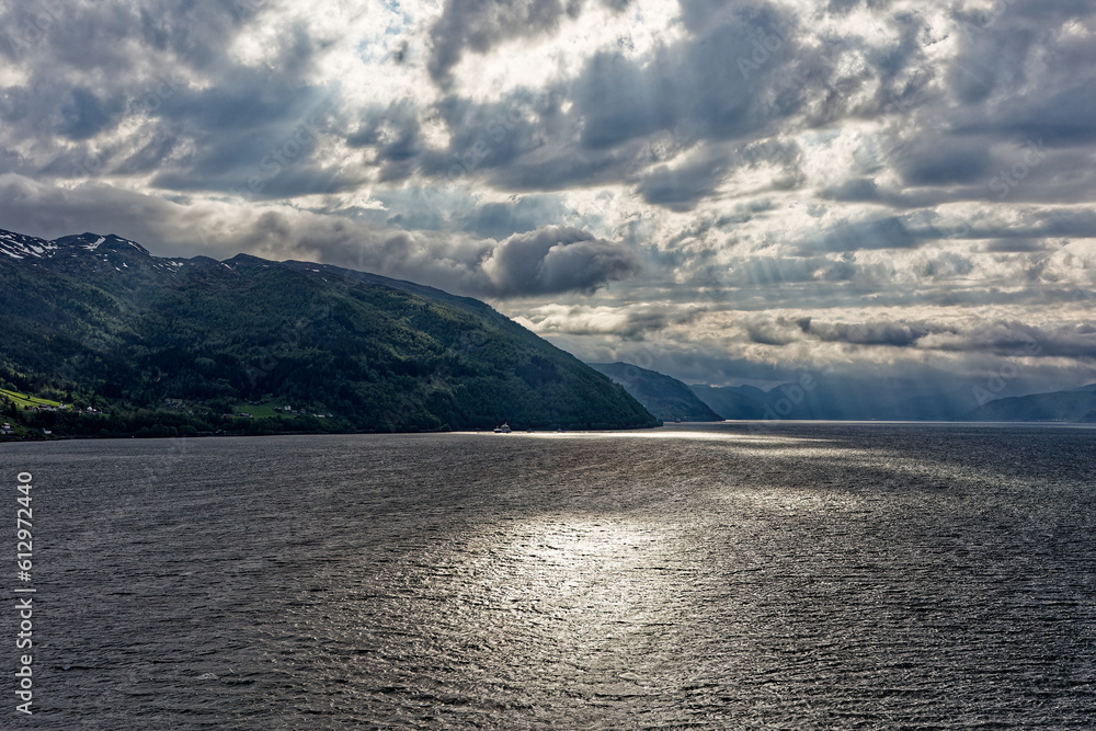 The fjord of Norway in the sun with dramatic clouds and scenery