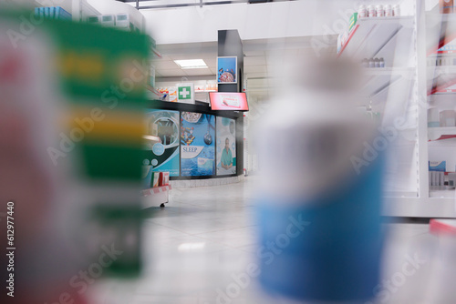 Selective focus of pharmacy counter desk filled with pharmaceutical products and computer, health space waiting for customers to come and buy pills. Drugstore shelves were stocked with drugs packages. © DC Studio