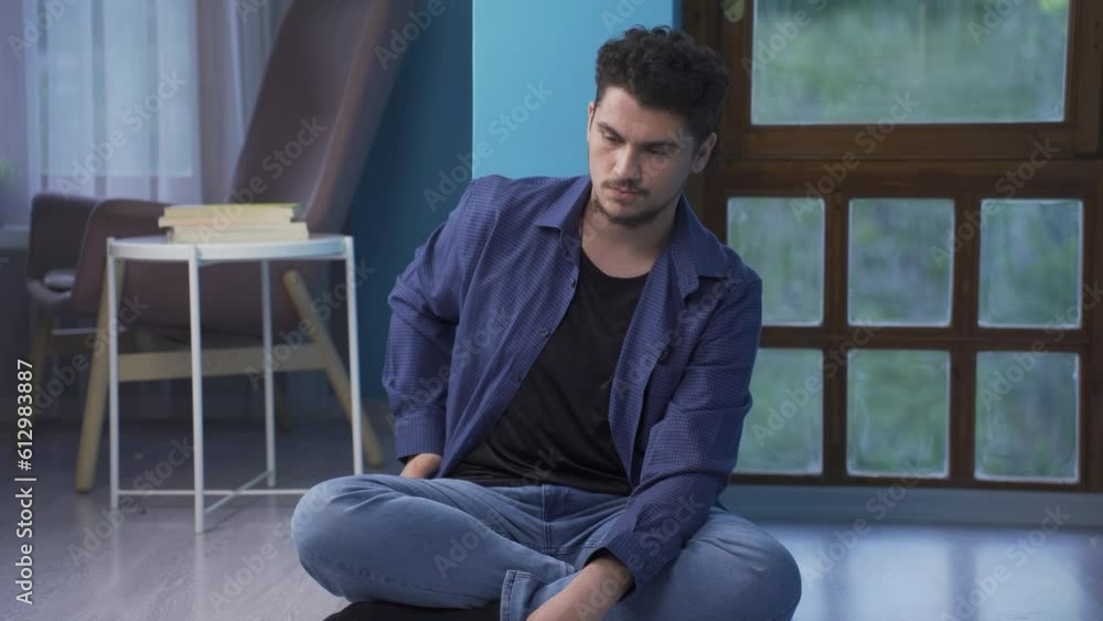 The man sitting by the wall looks at his empty wallet. Broke. The man sitting by the wall looks at his empty wallet. Broke.