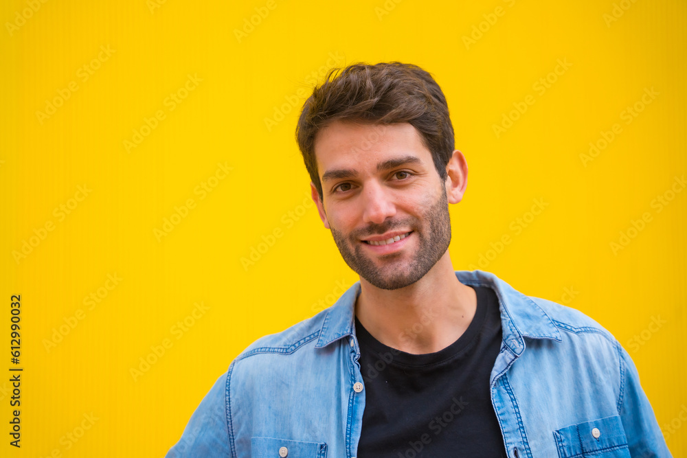 Portrait of a handsome excited model man in basic clothes smiling isolated over yellow background Portrait of a handsome excited model man in basic clothes smiling isolated over yellow background
