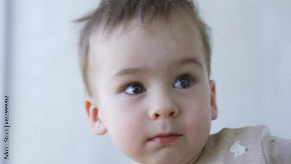 Face of a beautiful Caucasian baby boy. Smiling toddler runs up to a light switch to turn on the light. Face of a beautiful Caucasian baby boy. Smiling toddler runs up to a light switch to turn on the light.