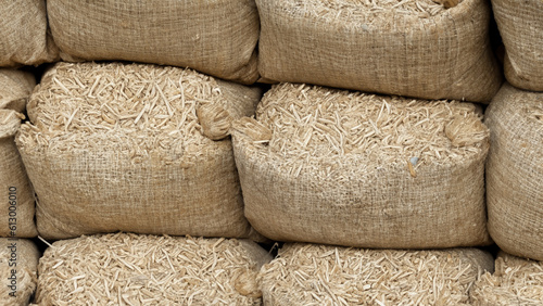 Pile of sacks in a row ful with wooden pellets - generative ai