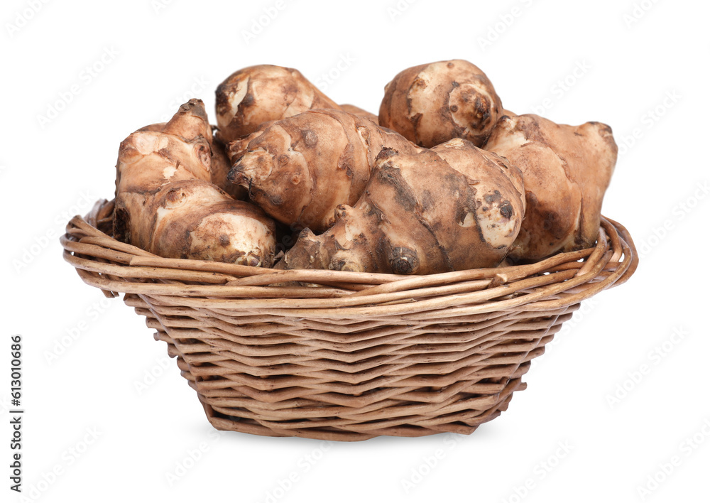 Wicker basket with many Jerusalem artichokes isolated on white Wicker basket with many Jerusalem artichokes isolated on white