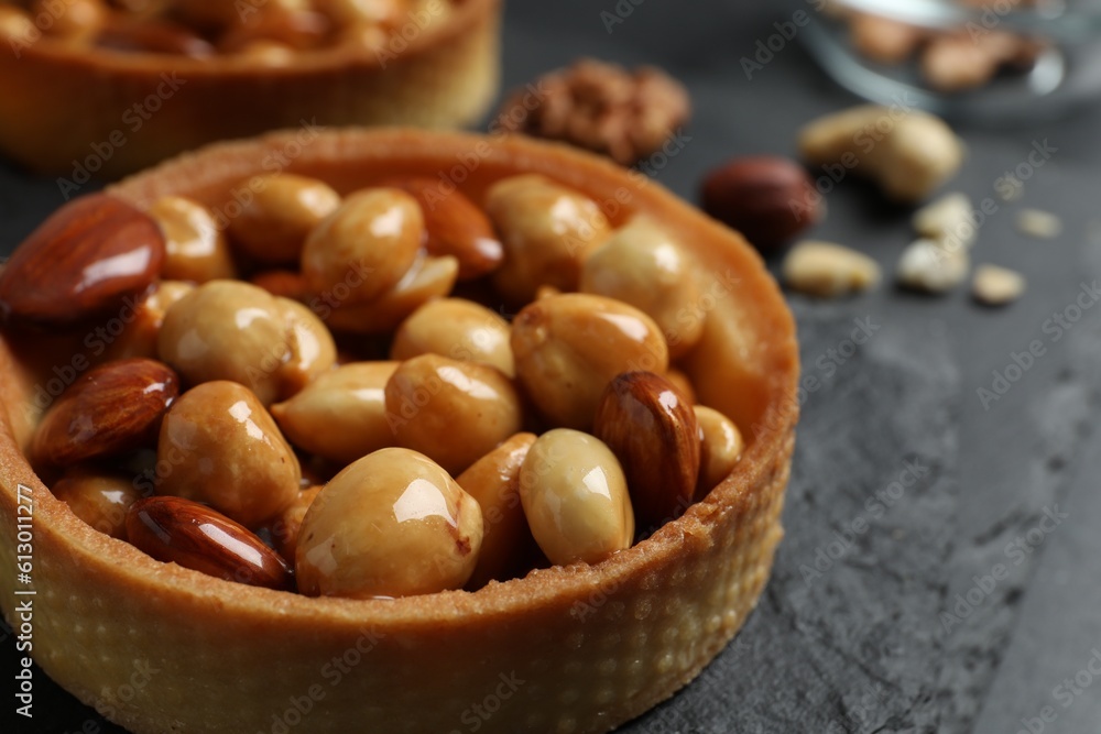Tartlet with caramelized nuts on black slate, closeup. Delicious dessert Tartlet with caramelized nuts on black slate, closeup. Delicious dessert