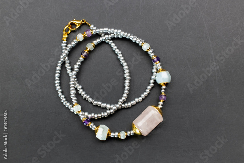 Colorful gemstone crystal beads necklace on black, unique handmade jewelry background, promotional photo for an online jewelry store