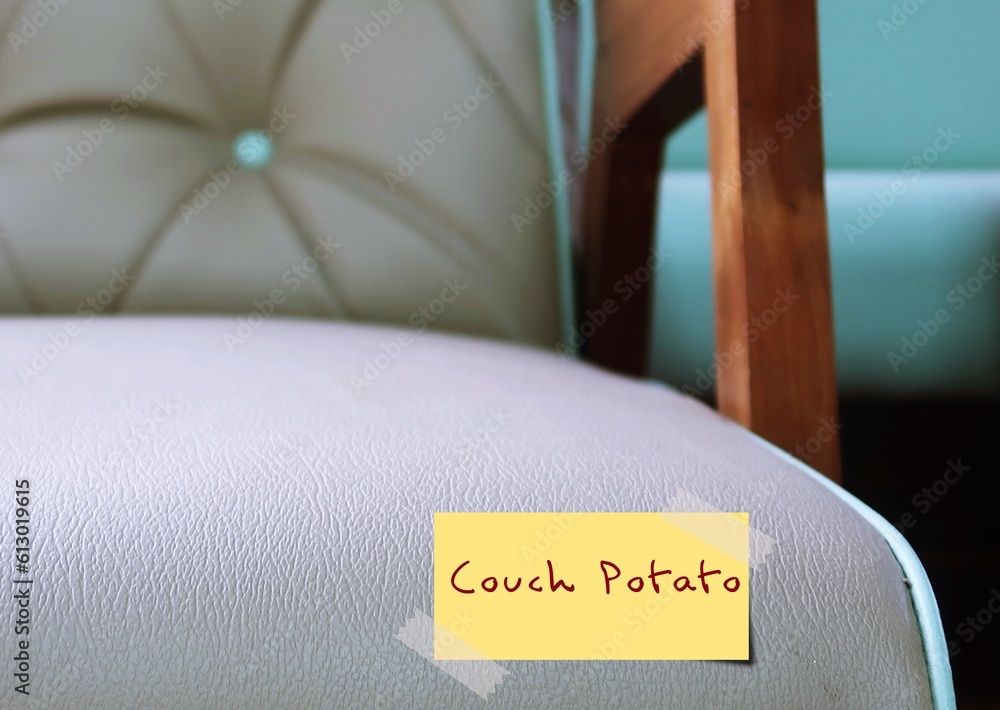 Sofa with handwritten stick note COUCH POTATO, refers to person who