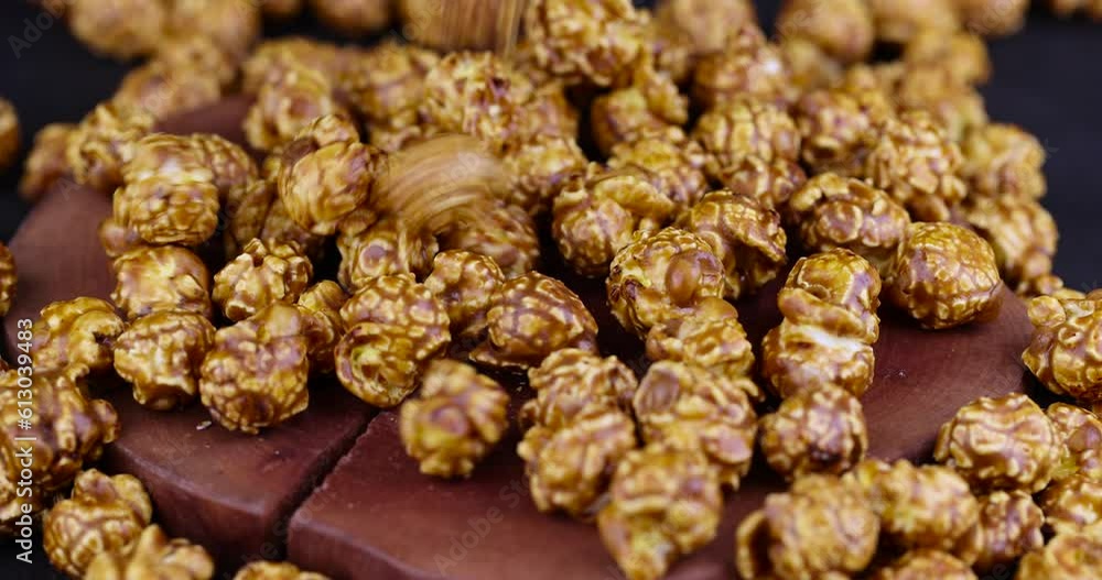 pour delicious sweet popcorn with lots of caramel, caramel flavor of popcorn close-up pour delicious sweet popcorn with lots of caramel, caramel flavor of popcorn close-up