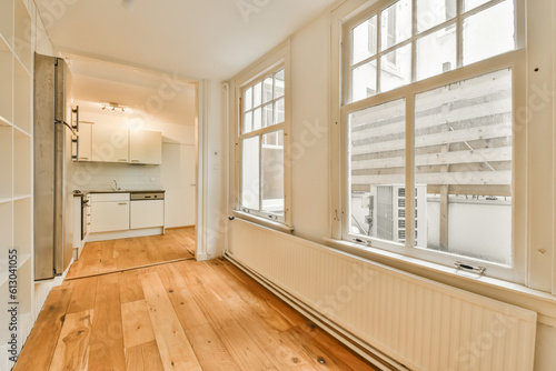 an empty living room with wood flooring and white walls in the room is very large, bright window view