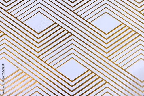 Shiny gold geometric lines on white paper top down view