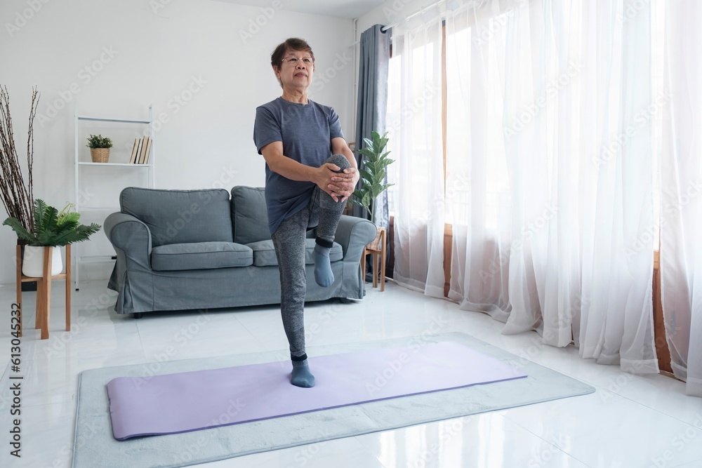 Active mature woman doing stretching exercise in living room at home. Active mature woman doing stretching exercise in living room at home.