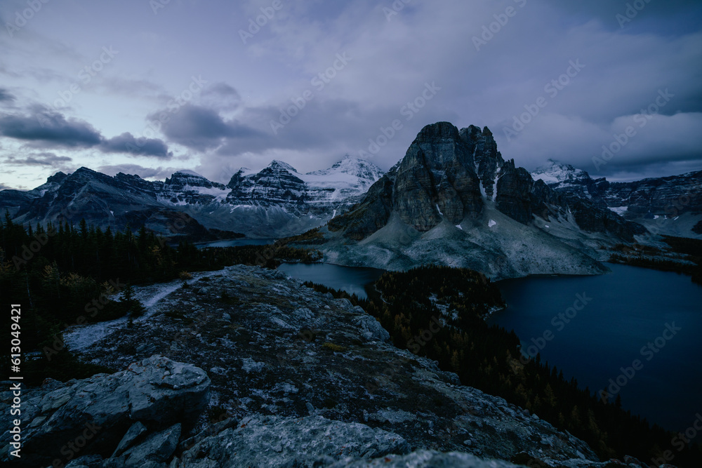vue sur la vallée avec un lac et de grandes montagnes avec le sommet derrière enneigé avant le lever du soleil