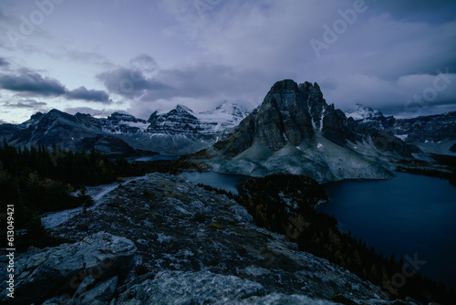 vue sur la vallée avec un lac et de grandes montagnes avec le sommet derrière enneigé avant le lever du soleil