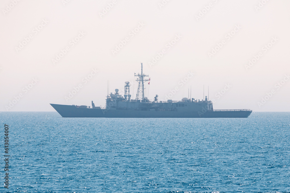 A military warship on the horizon in the open sea