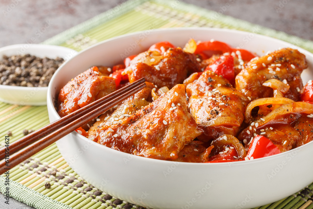 Stir-fried black pepper chicken with vegetables in a spicy sauce close-up in a plate on the table. Horizontal Stir-fried black pepper chicken with vegetables in a spicy sauce close-up in a plate on the table. Horizontal