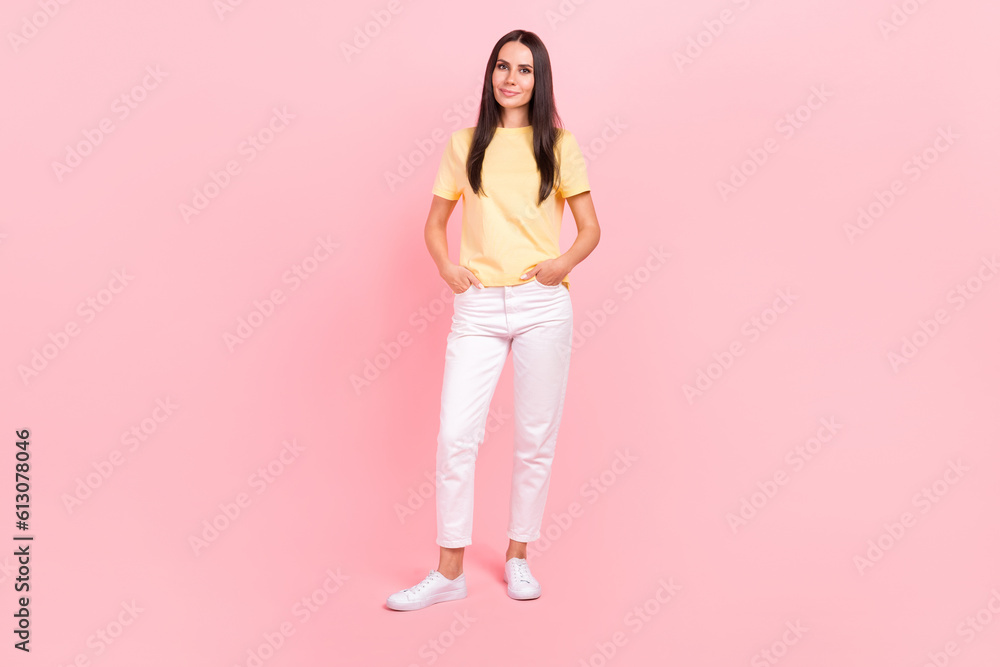 Full length photo of cute sweet woman dressed yellow t-shirt hands pockets walking isolated pink color background Full length photo of cute sweet woman dressed yellow t-shirt hands pockets walking isolated pink color background