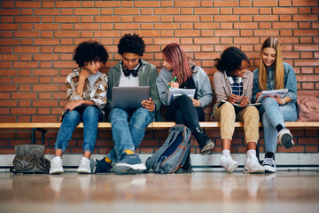 Multiracial group of high school students learn together at school.