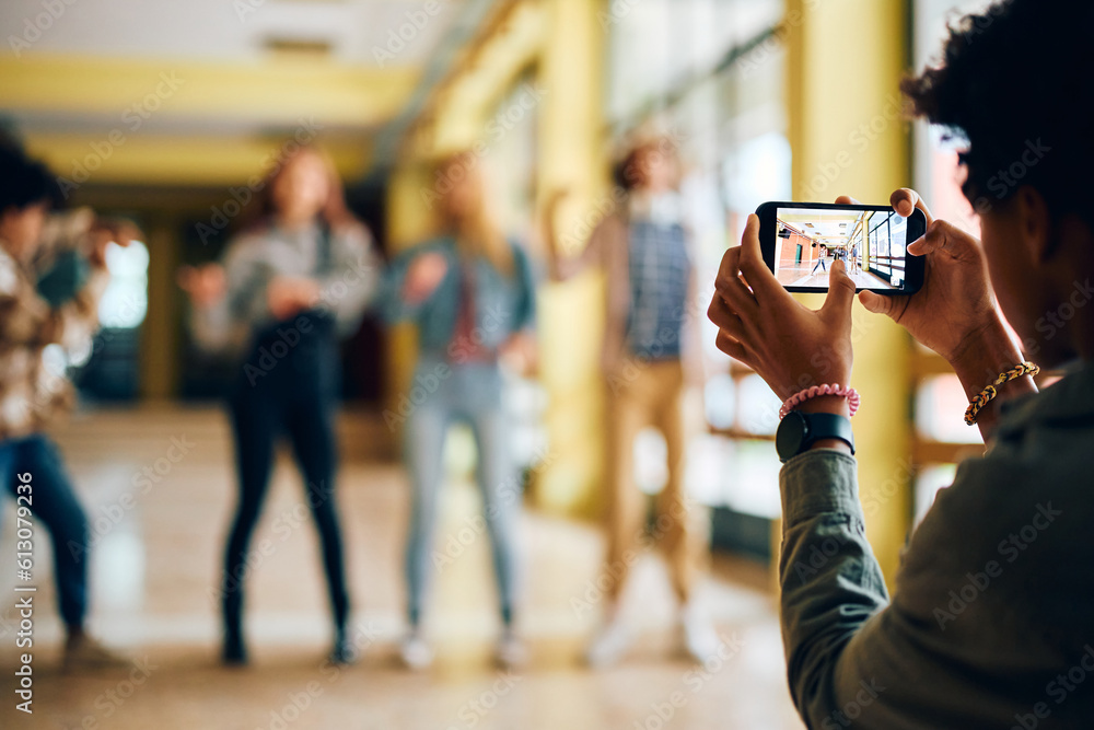 Obraz premium Close up of high school student takes picture of his friends with smart phone.