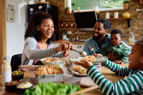 Happy African American family enjoying in meal at dining table.