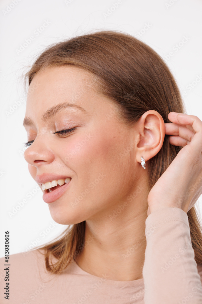 Beautiful young girl with fresh healthy skin. Woman advertise ear-rings. White background. Earrings closeup. Blond european woman with long hair with big lips, pretty smile. Cosmetology, scincare Beautiful young girl with fresh healthy skin. Woman advertise ear-rings. White background. Earrings closeup. Blond european woman with long hair with big lips, pretty smile. Cosmetology, scincare