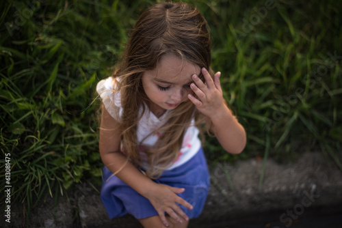 Little girl thinking with hand on forehead