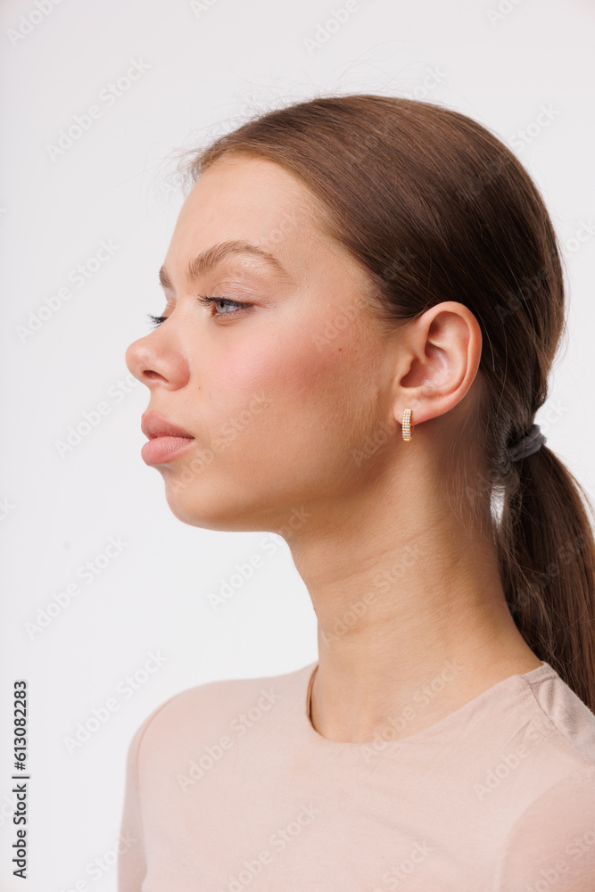 Beautiful young girl with fresh healthy skin. Woman advertise ear-rings. White background. Earrings closeup. Blond european woman with long hair with big lips, pretty smile. Cosmetology, scincare Beautiful young girl with fresh healthy skin. Woman advertise ear-rings. White background. Earrings closeup. Blond european woman with long hair with big lips, pretty smile. Cosmetology, scincare