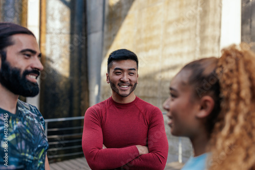 Happy multiracial young people in sports clothes socializing