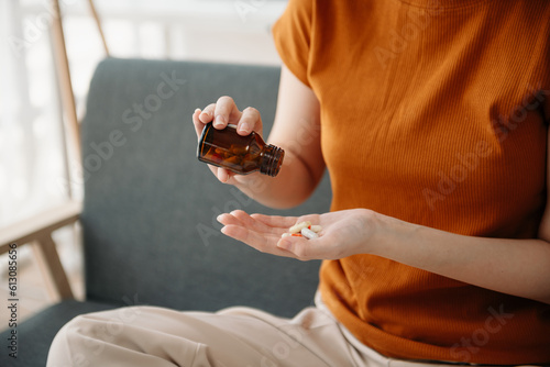  woman sit Depression Dark haired pensive glance Standing with glass of water and pills by window