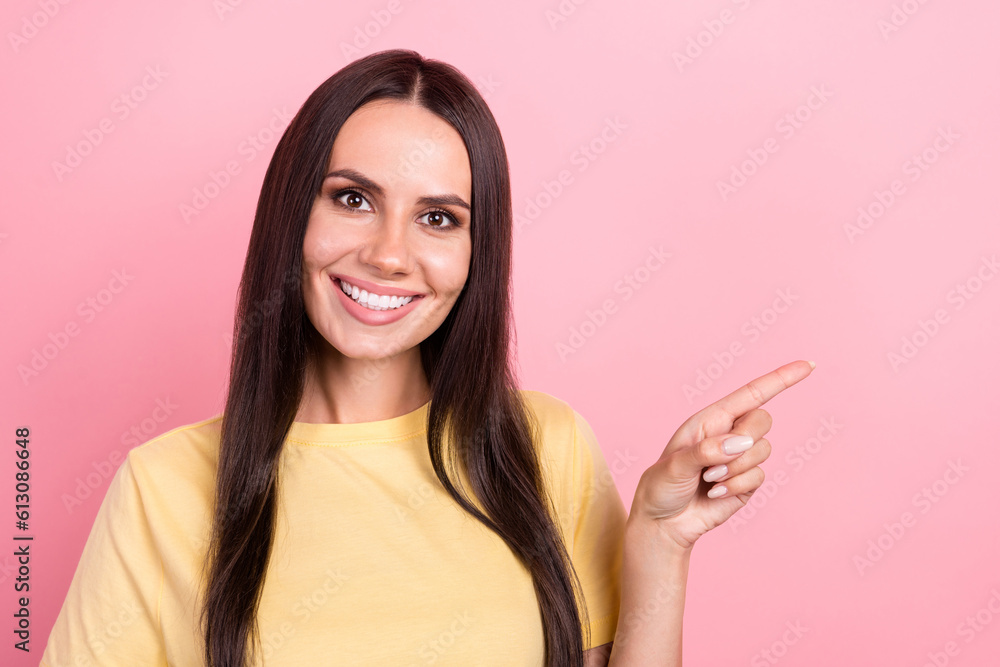Photo of cheerful positive woman dressed yellow t-shirt smiling pointing finger empty space isolated pink color background Photo of cheerful positive woman dressed yellow t-shirt smiling pointing finger empty space isolated pink color background