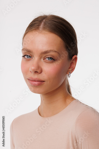 Beautiful young girl with fresh healthy skin. Woman advertise ear-rings. White background. Earrings closeup. Blond european woman with long hair with big lips, pretty smile. Cosmetology, scincare