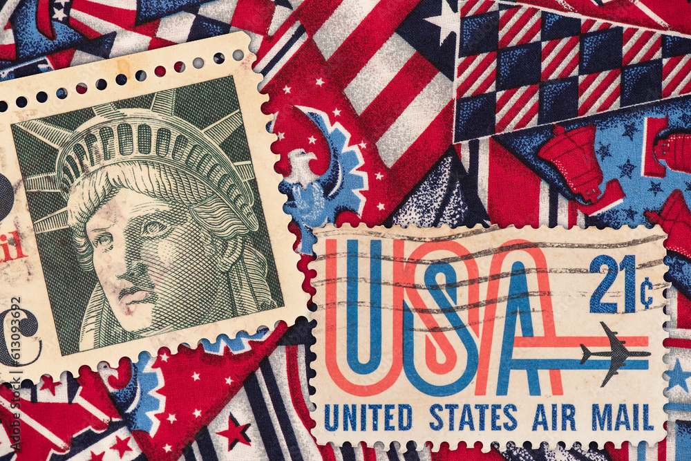 Old united states and statue of liberty stamps on fabric background with american symbol print background. Old united states and statue of liberty stamps on fabric background with american symbol print background.