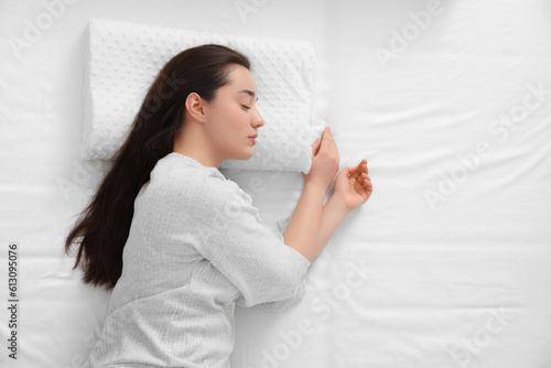 Woman sleeping on memory foam pillow, top view. Space for text