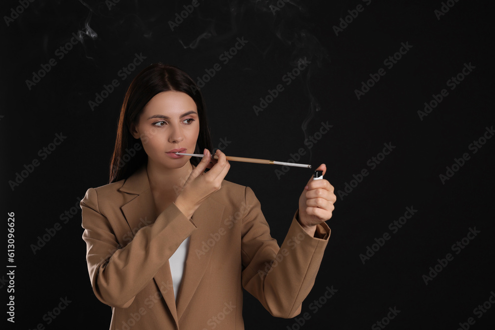 Obraz premium Woman using long cigarette holder for smoking on black background, space for text