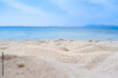 Beach sand background for summer vacation concept. Beach nature and summer seawater with sunlight light sandy beach Sparkling sea water contrast with the blue sky. 