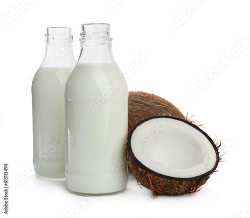 Bottles with coconut milk and nuts on white background
