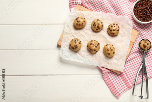 Uncooked chocolate chip cookies on white wooden table, flat lay. Space for text