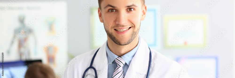 Portrait of handsome male doctor in modern clinic. Health insurance and services concept Portrait of handsome male doctor in modern clinic. Health insurance and services concept
