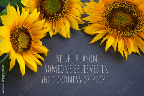 Inspirational quote - Be the reason someone believe in the goodness of people. With three sunflowers on gray background. Kindness concept with yellow flowers floral backgrounds.