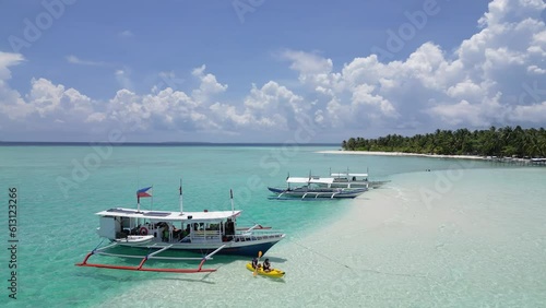 Kayaker tourists disembark from double outrigger banca boats to onok island photo