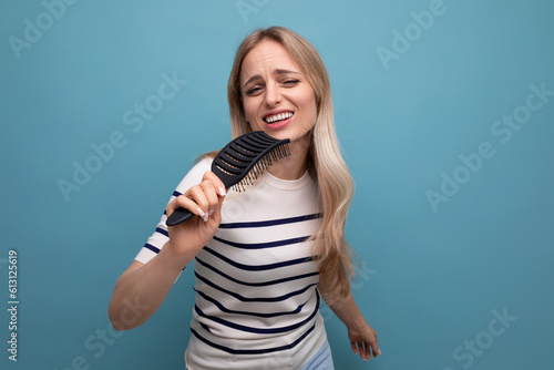 happy well-groomed european blond woman with healthy hair on a blue isolated background