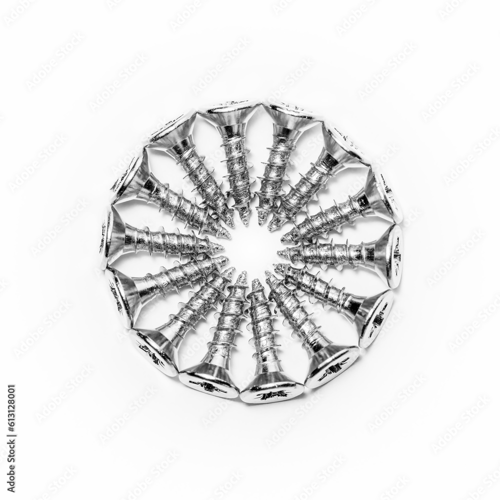 Screws neatly arranged in a circle on a white background. Zinc head screws. Screws neatly arranged in a circle on a white background. Zinc head screws.