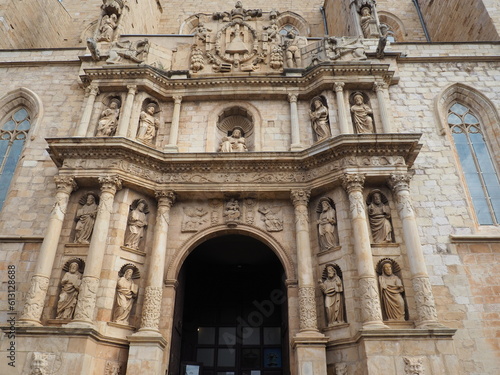 fachada principal de la iglesia románica de santa maría la mayor de montblanch con los doce apóstoles, estilo barroco, columnas corintias, virgen maría custodiada por dos ángeles, escultura de dios 