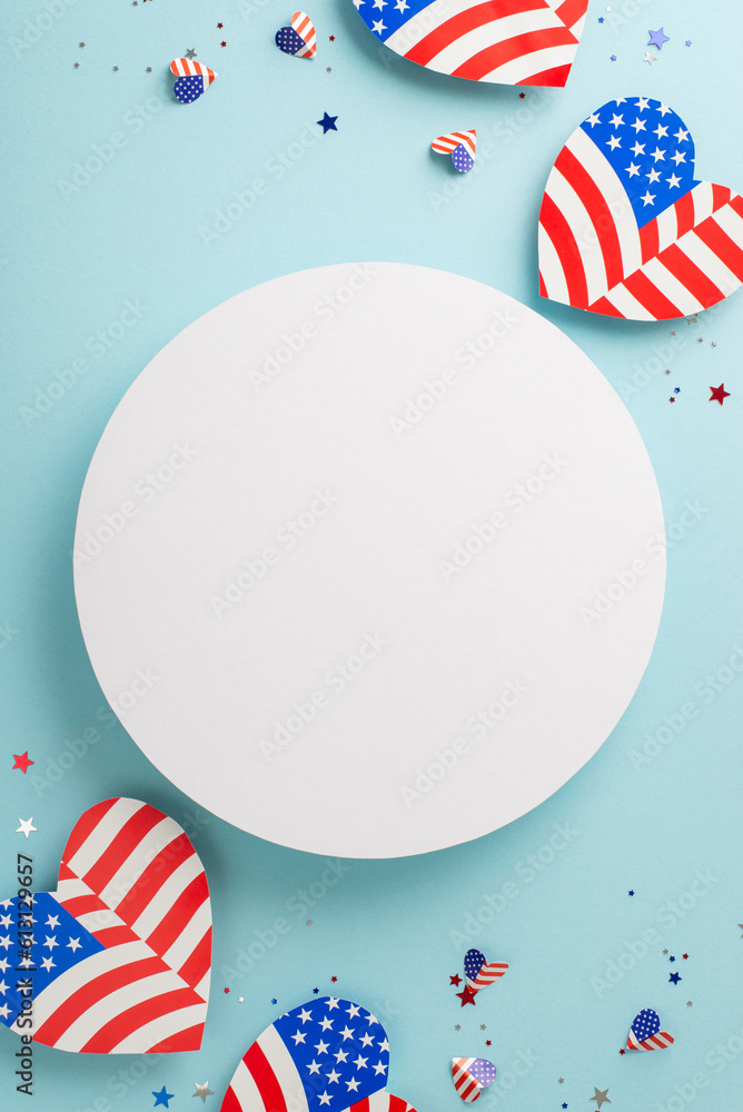 Fototapeta premium Freedom Fest festivities. Vertical top view of representative ornaments: hearts with American flag motif, sparkling confetti on a soft blue background with a blank circle for text or promotion