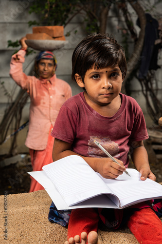 Fotografija Small Indian asian construction labour girl child studying while mother working