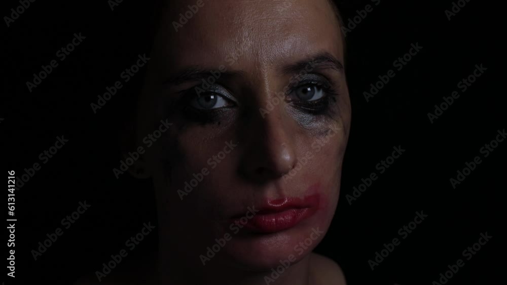 Upset young tearful woman with leaky mascara makeup on black background Upset young tearful woman with leaky mascara makeup on black background